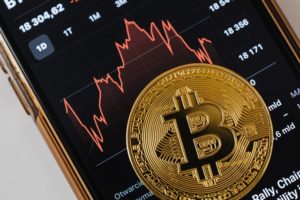 Złota moneta Bitcoin na ekranie telefonu